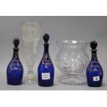 Three Bristol blue glass decanters and stoppers, Brandy, Rum and Hollands, and two vases tallest