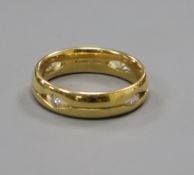 A modern pierced 18ct gold band, set with four gypsy set diamonds, size N.