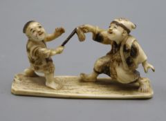 A Japanese okimono of two boys, signed length 10cm