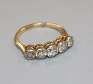 An 18ct gold and graduated five stone diamond half hoop ring, size O.