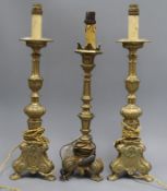 A pair of brass candlesticks and a similar one tallest 39.5cm