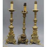 A pair of brass candlesticks and a similar one tallest 39.5cm