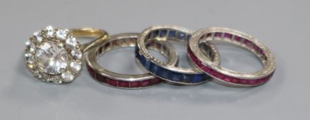 A 9ct gold paste-set ring and three white metal eternity rings, one sapphire and two ruby channel-