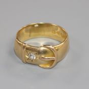 An early 20th century 18ct gold and diamond set buckle ring, size Q.