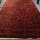 A Persian red ground carpet, with field of palmette motifs, multi-bordered 339 x 230cm