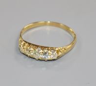 An 18ct gold and graduated claw set five stone diamond ring, size Q.