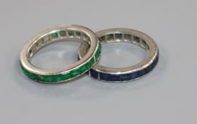 An emerald channel-set eternity ring, white metal setting (tests as platinum, two stones missing)