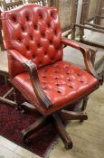 A buttoned red leather mahogany desk chair