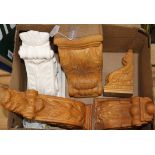 Four carved wood corbels and a similar plaster corbel