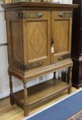 An Arts & Crafts inlaid oak cabinet, with copper mounts W.98cm