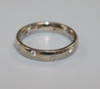 A modern 18ct white gold and gypsy set diamond band, size I.