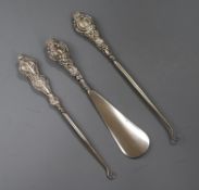Two early 20th century silver handled button hooks and a silver handled shoe horn.