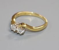 A modern 18ct gold and two stone diamond crossover ring, size J.