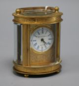 A 20th century oval engraved brass carriage timepiece, the circular dial marked Elliot and Son