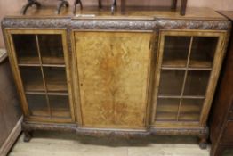 A 1930's carved and figured walnut breakfront dwarf bookcase, W.156cm