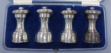 A cased set of four George V silver capstan shaped pepper mills, Hukin & Heath Ltd, Birmingham 1913,