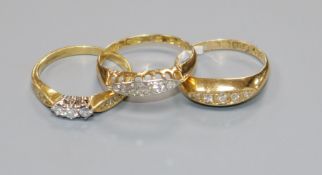 Two early 20th century 18ct gold and five stone diamond rings and a later 18ct gold and three