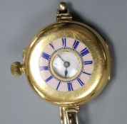 An 18ct gold and enamel half hunter manual wind wrist watch by Smith & Son, London, on a 9ct gold
