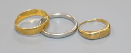 A 22ct. gold band, a platinum band and a yellow metal band.