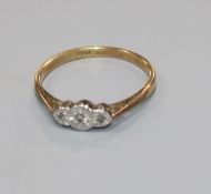 An 18ct gold, platinum and three stone illusion set diamond ring, size P.