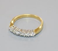 A modern 18ct gold and seven stone diamond half hoop ring, size L.