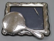 A modern silver mounted photograph frame, a silver mounted hand mirror and a white metal