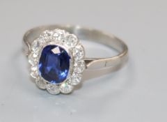 A mid 20th century white metal, synthetic sapphire? and diamond cluster dress ring, size O/P.