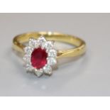 A modern 18ct gold, ruby and diamond cluster ring, size L.