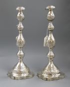 A pair of George V silver shabbat candlesticks, of embossed baluster form on domed shaped bases,