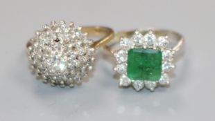 An 18ct white gold, emerald and diamond cluster ring and a 9ct gold and diamond cluster ring.