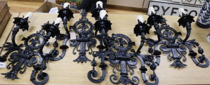 A set of four Spanish black japanned wrought iron wall sconces, each of scrolled openwork form