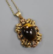 An Austrian yellow metal and tiger's eye quartz set pendant, on a yellow metal chain, pendant 30mm.