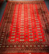 A Bokhara style red ground rug 270 x 193cm