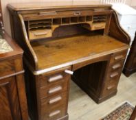 A 1920's oak tambour desk W.122cm