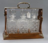 A Betjemanns walnut three decanter tantalus, lacking keys