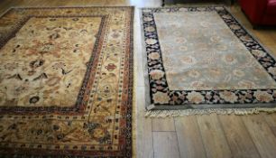 A Persian cream and pink ground carpet and a smaller carpet, with dark blue border (2) 245 x