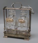 An Asprey silver plated tantalus with two decanters and three modern silver labels, Whisky, Brandy