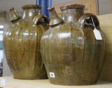 Two similar 17th century French, Auvergne, terracotta spouted jars, with triple strap handles and