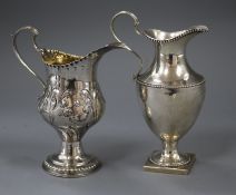 Two George III silver cream jugs, one with later embossed decoration, the other with repair, tallest