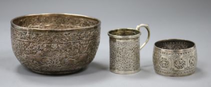 An Indian white metal sugar bowl, a cup and a serviette ring.