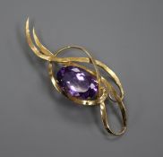 A yellow metal and amethyst set scrolling brooch, 83mm.