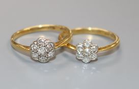 Two early-mid 20th century 18ct gold and diamond cluster flower head rings.