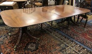 A Regency style mahogany two pillar dining table and two leaves W.265cm