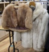 A white fox fur jacket and brown fox cape