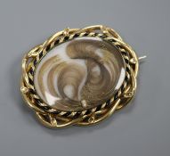 A Victorian yellow metal mounted mourning brooch brooch, with locks of hair below glazed panel,