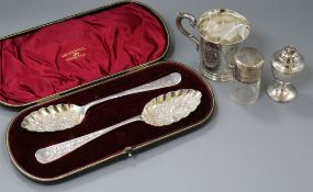A cased pair of silver berry spoons, a silver mounted salts bottle, a silver pepper and a silver