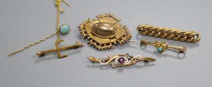 Five assorted yellow metal brooches including gem set and a stick pin.