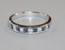 A modern 18ct white gold, eleven stone sapphire and diamond half eternity ring, size R.
