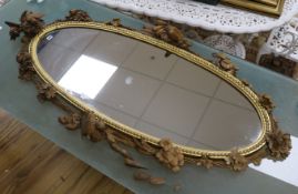 An early 20th century French ornately carved fruitwood and giltwood mirror W.170cm