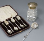 A silver topped bottle , caster and spoons.
